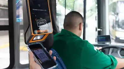 Una persona pagando el boleto del colectivo con el celular Una persona pagando el boleto del colectivo con el celular