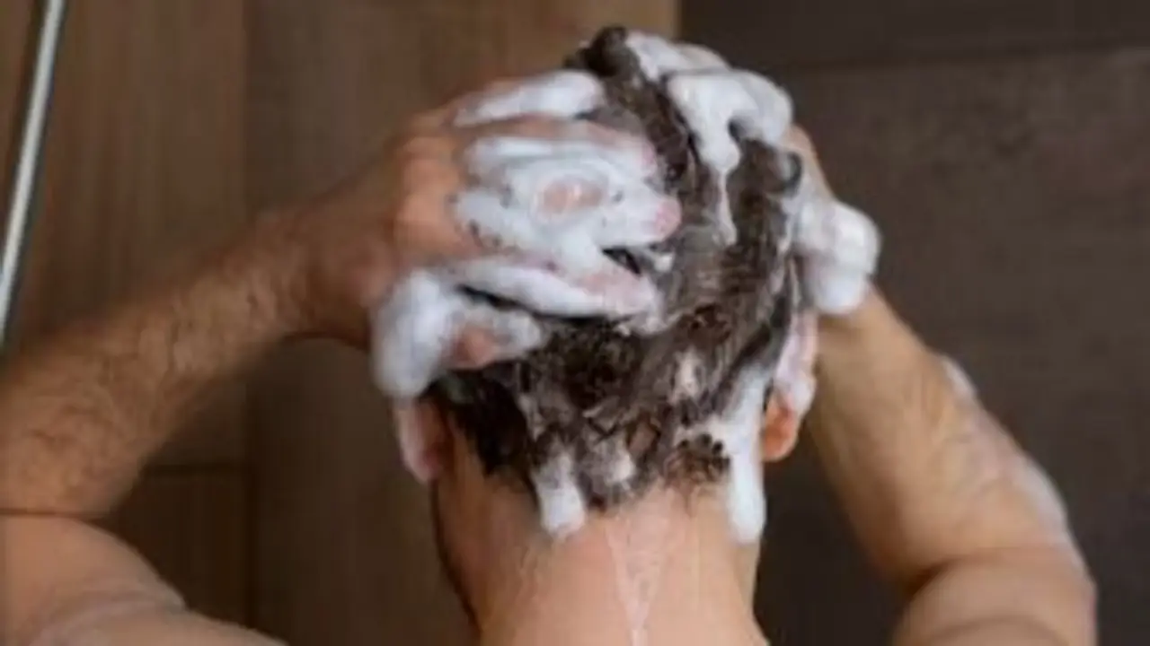 persona lavándose el pelo.