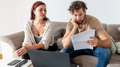 Pareja preocupada revisando papeles y costos de alquiler en Argentina 2025 Pareja preocupada revisando papeles y costos de alquiler en Argentina 2025