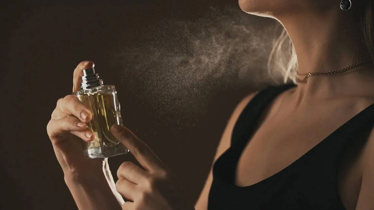 Mujer poniéndose perfume