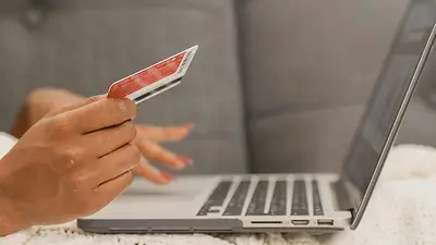 Una persona con la tarjeta frente a una computadora Una persona con la tarjeta frente a una computadora