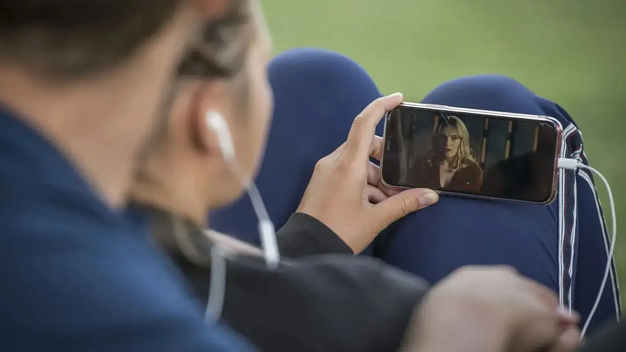 Personas ven serie o película en el celular