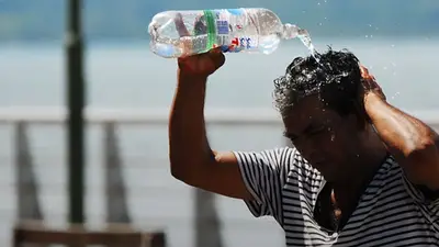 Un hombre tirándose una botella de agua en la cabeza Un hombre tirándose una botella de agua en la cabeza