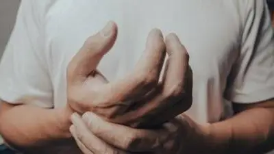 Persona tocándose la mano. Persona tocándose la mano.