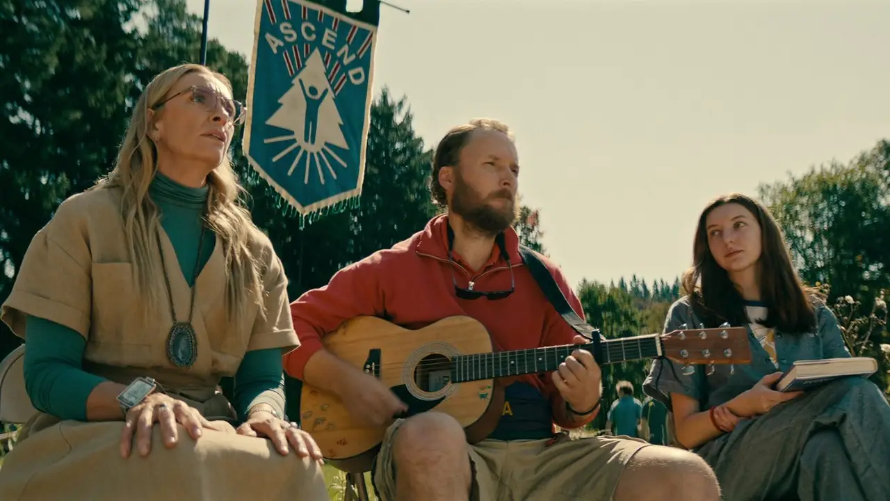 Elenco de serie de Netflix. Tres actores con una guitarra en un día con mucho sol, en el bosque