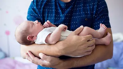 Un hombre con un bebé en brazos. Un hombre con un bebé en brazos.