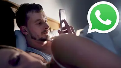 Una hombre usando WhatsApp en la cama, mientras su pareja duerme Una hombre usando WhatsApp en la cama, mientras su pareja duerme
