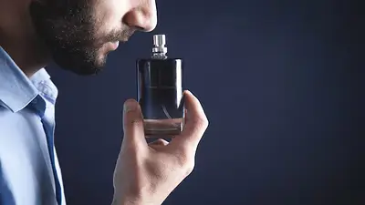 Un hombre olfateando un perfume Un hombre olfateando un perfume