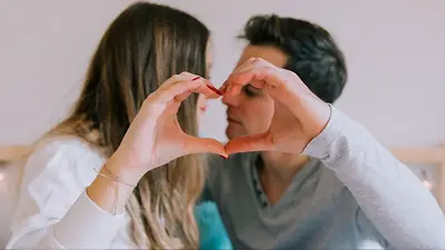 Una pareja formando un corazón con sus manos Una pareja formando un corazón con sus manos