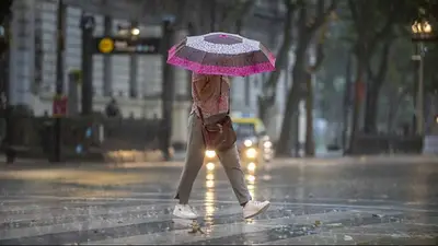 Mujer con paragua caminando bajo la lluvia Mujer con paragua caminando bajo la lluvia