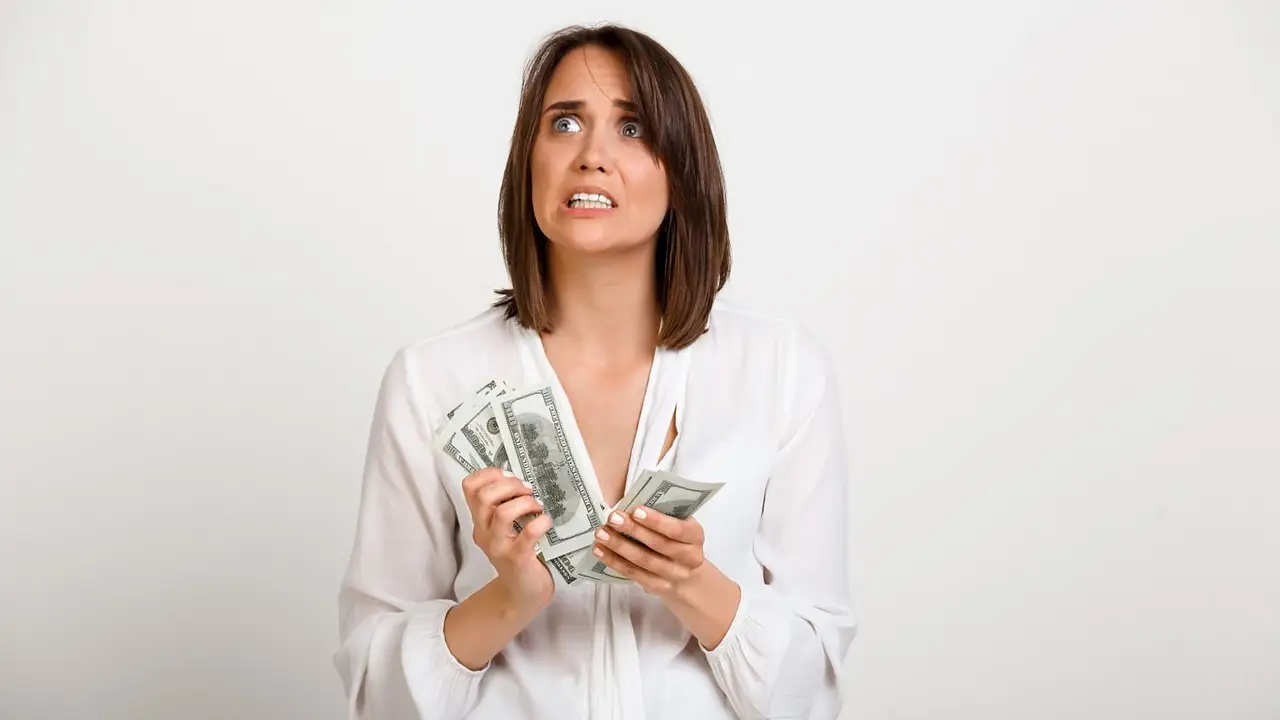 Una mujer con billetes en la mano