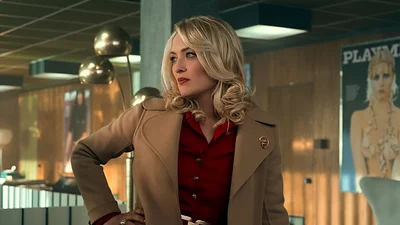 protagonista de serie posa con abrigo en una oficina de la revista Playmen protagonista de serie posa con abrigo en una oficina de la revista Playmen