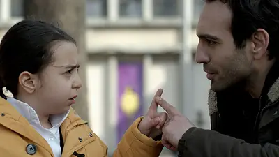 Niña y señor tocan sus dedos y se ven a los ojos Niña y señor tocan sus dedos y se ven a los ojos