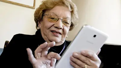 Jubilada sostiene un celular Jubilada sostiene un celular