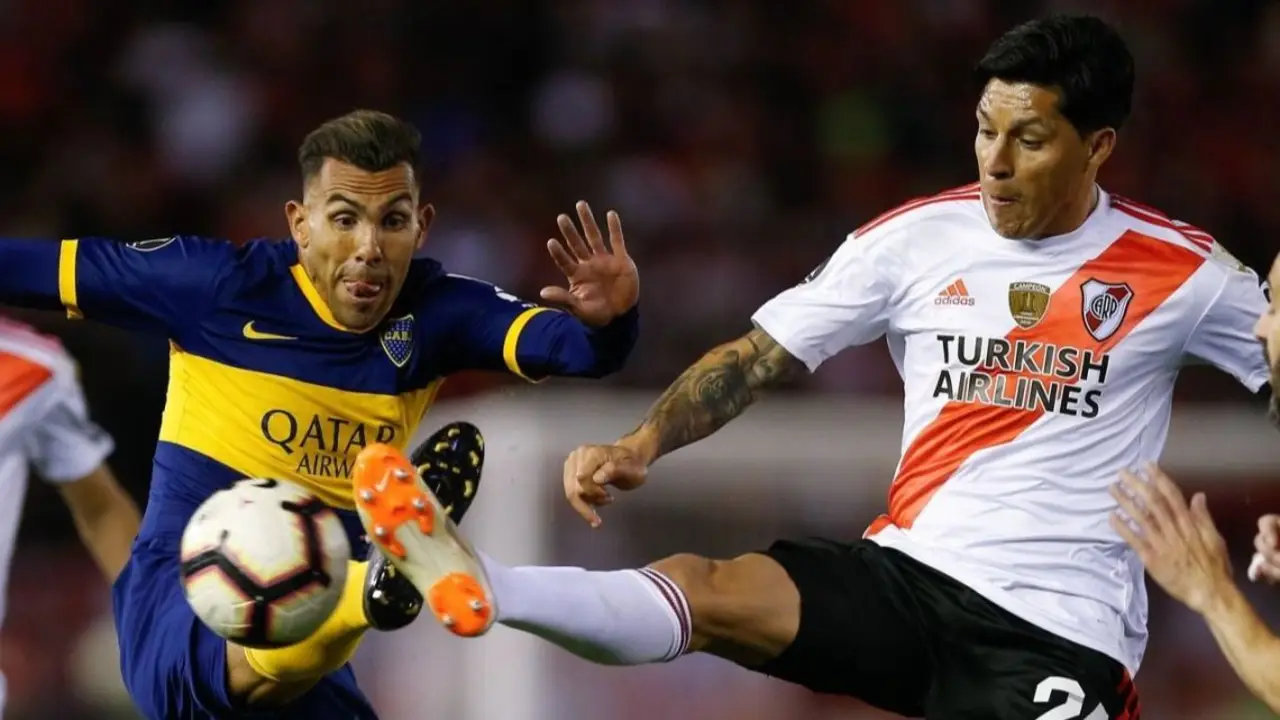 Carlos Tevez y Enzo Pérez disputan una pelota en un partido entre Boca y River