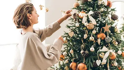 Una mujer arma un arbolito de Navidad. Una mujer arma un arbolito de Navidad.