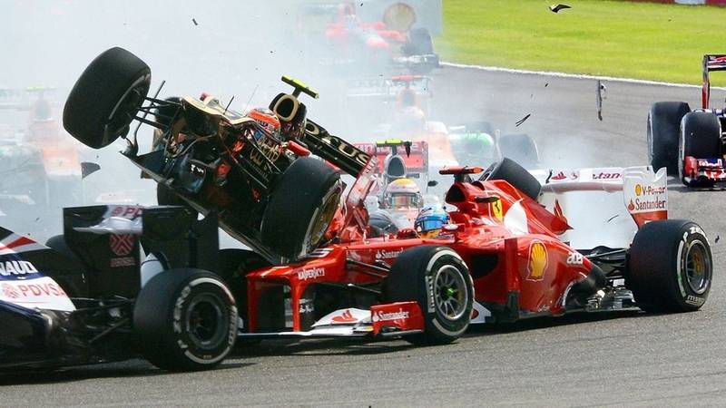 Dos coches de F1 chocando en pista.