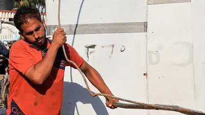 Desesperados gazatíes sacan barras de hierro de los escombros para construir tiendas Desesperados gazatíes sacan barras de hierro de los escombros para construir tiendas