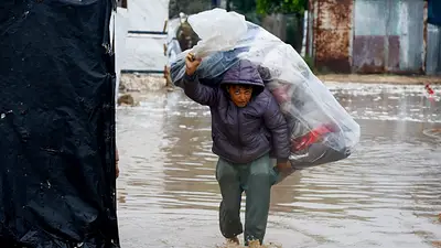 Palestinos desplazado caminando en medio de las inundaciones de la Franja de Gaza Palestinos desplazado caminando en medio de las inundaciones de la Franja de Gaza