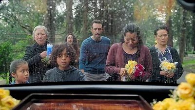 Grupo de personas camina detrás de un auto fúnebre Grupo de personas camina detrás de un auto fúnebre
