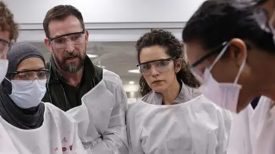 Escena de The Pitt: médicos con batas blancas y cubrebocas Escena de The Pitt: médicos con batas blancas y cubrebocas
