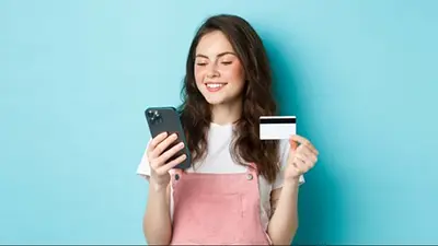 Persona usando el cupo en dólares de una tarjeta de crédito desde el celular Persona usando el cupo en dólares de una tarjeta de crédito desde el celular