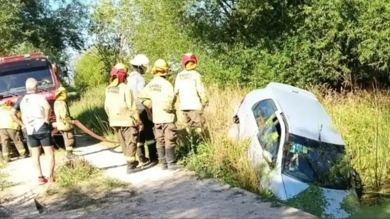 Bomberos en el operativo para sacar el auto del arroyo.